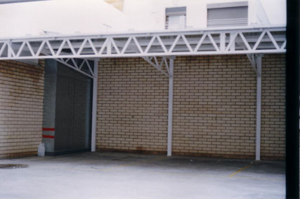 Cubierta de garaje formado por celosia  y soportes de peril tubular y cubierta de panel sandwich