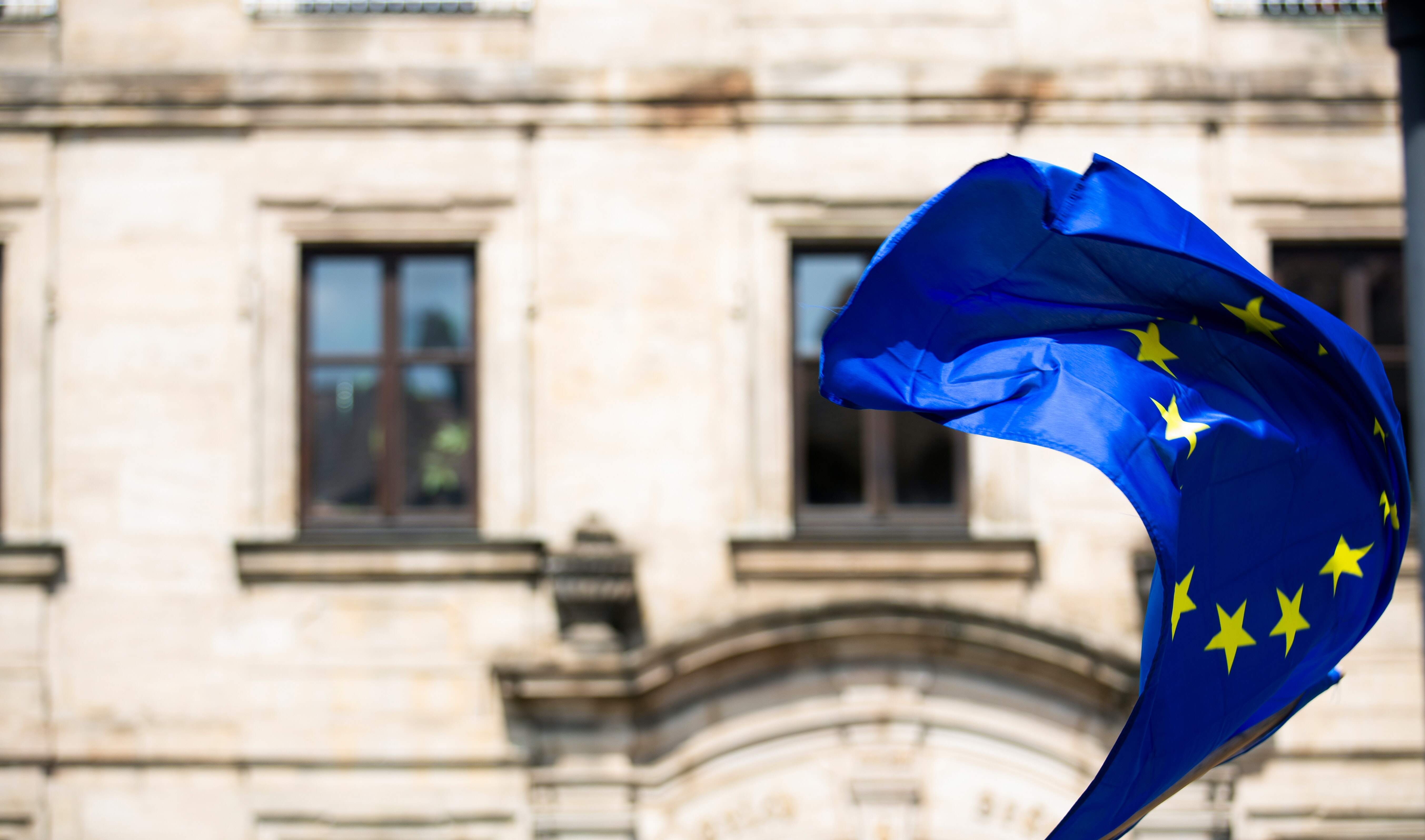 Bandera de la Unión Europea ondeante delante de la Oficina de obtención del Certificado de registro del ciudadano de la UE