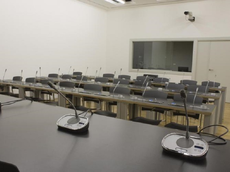 Sala de prensa con tres microfonos profesionales sobre una mesa