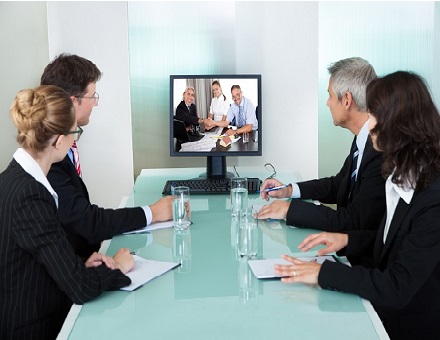 Hombres y mujeres asistiendo a una reunion con videoconferencia