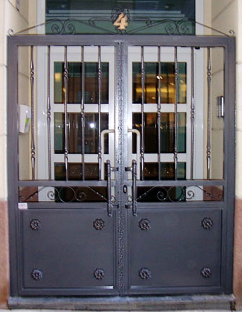 Puerta de hierro con barrotes de forja y fijo inferior de chapa