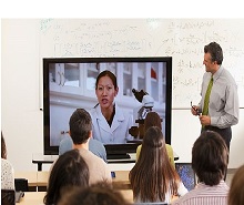 Alumnos en un aula asistiendo a una videoconferencia